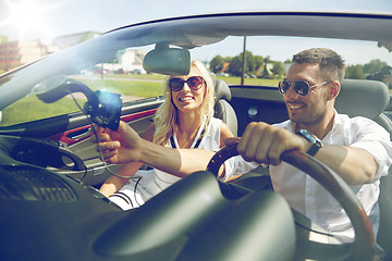 Image showing happy couple using gps navigator in cabriolet car