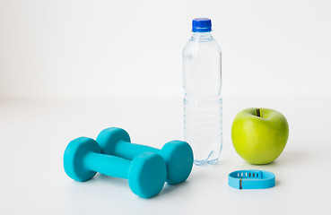 Image showing dumbbells, fitness tracker, apple and bottle