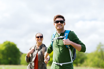 Image showing happy couple with backpacks hiking outdoors