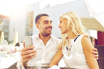 Image showing couple taking selfie with smatphone at restaurant