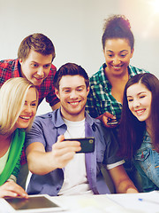 Image showing students looking into smartphone at school