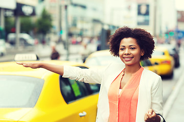 Image showing happy african woman catching taxi