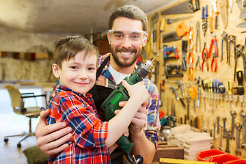 Image showing father and son with drill working at workshop