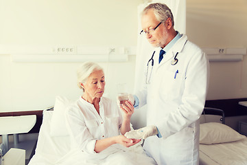 Image showing doctor giving medicine to senior woman at hospital