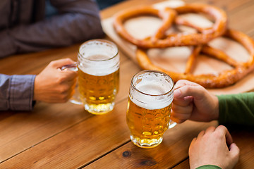 Image showing close up of hands with beer mugs at bar or pub