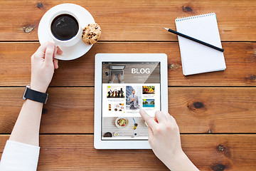 Image showing close up of woman with tablet pc on wooden table