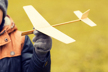 Image showing close up of little boy holding toy plane outdoors