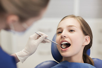 Image showing female dentist checking patient girl teeth