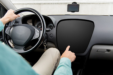 Image showing man driving car and pointing to on-board computer