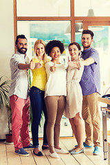 Image showing happy creative team showing thumbs up in office