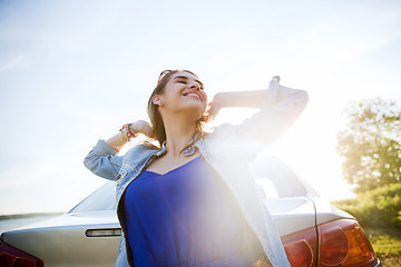 Image showing happy teenage girl or young woman near car