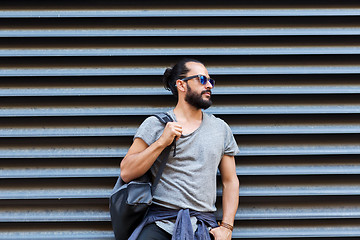 Image showing man with backpack standing at city street wall