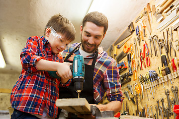 Image showing father and son with drill working at workshop