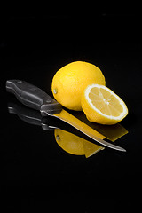 Image showing lemon and kitchen knife with black background
