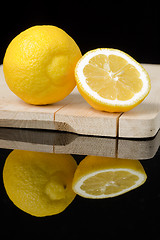 Image showing lemon on wood table with black background