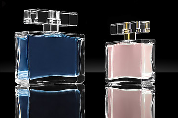 Image showing blue and pink elegant perfume bottles in black background