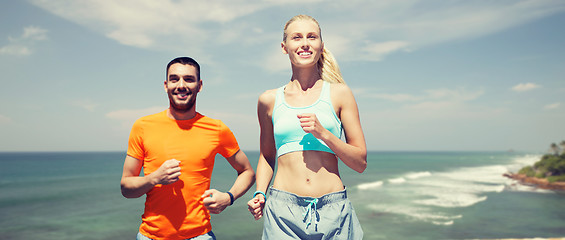 Image showing happy couple running over sea or beach background