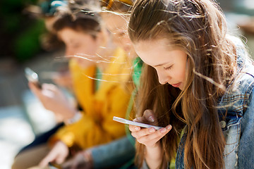 Image showing happy teenage friends with smartphones outdoors