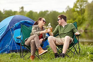 Image showing happy couple clinking drinks at campsite tent