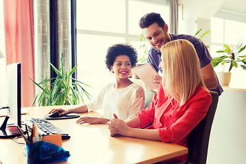 Image showing happy creative team with computer in office