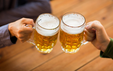 Image showing close up of hands with beer mugs at bar or pub