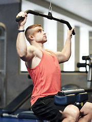 Image showing man flexing muscles on cable machine gym