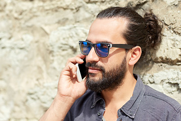 Image showing smiling man with smartphone calling on city street