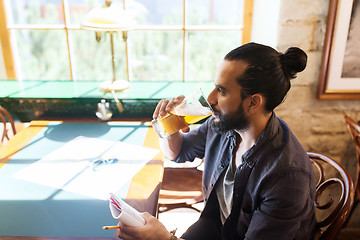 Image showing man with notebook drinking beer at bar or pub