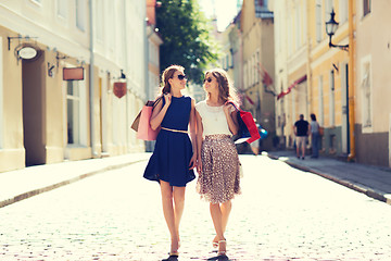 Image showing happy women with shopping bags walking in city