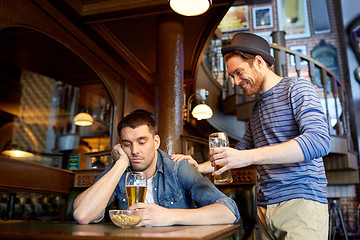 Image showing man with beer and drunk friend at bar or pub