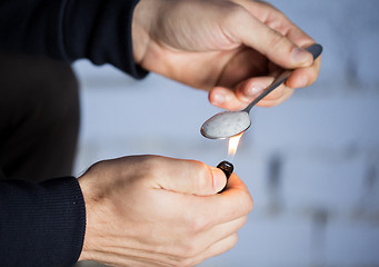 Image showing close up of addict preparing crack cocaine drug