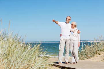 Image showing happy senior couple hugging on summer beach