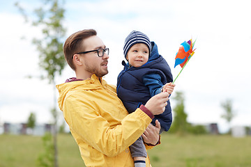 Image showing happy father and son with pinwheel toy outdoors