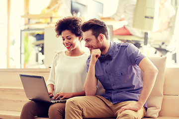 Image showing happy creative team with laptop in office