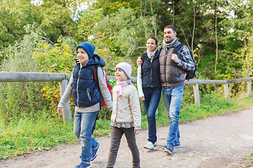 Image showing happy family with backpacks hiking in woods