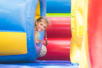 Image showing Happy little girl got out of the inflatable soft barrel while playing on the trampoline