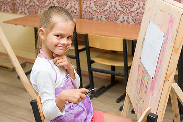 Image showing Girl artist with a smile look in the picture on the drawing lesson