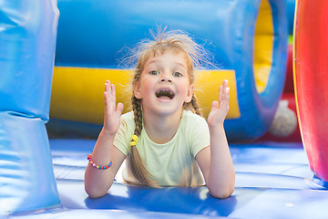 Image showing Happy girl lying on a big inflatable trampoline game