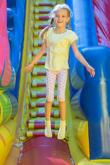 Image showing Happy girl jumping on an inflatable trampoline