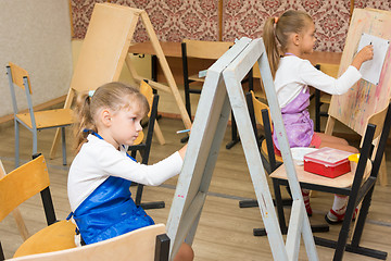 Image showing Two girls at a drawing lesson paint on easels