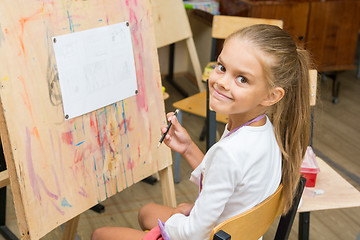 Image showing Girl happily looks into the frame on a drawing lesson