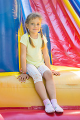 Image showing Five-year girl sitting on a big inflatable trampoline