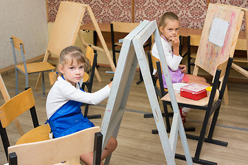 Image showing Two girls at a drawing lesson listen to the teacher\'s explanations