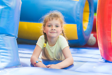 Image showing Disheveled five year old girl is playing on a big inflatable trampoline