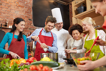 Image showing happy friends and chef cook cooking in kitchen