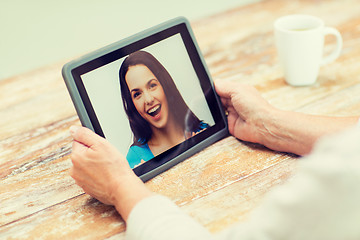 Image showing senior woman with photo on tablet pc at home