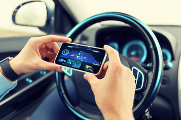 Image showing hands with navigator on smartphone in car