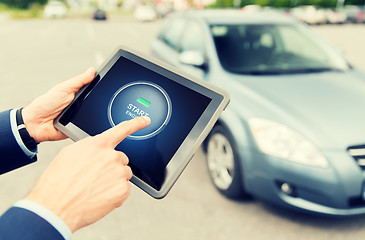 Image showing close up of hands with car starter on tablet pc