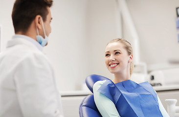 Image showing happy male dentist with woman patient at clinic