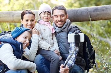 Image showing happy family with smartphone selfie stick in woods